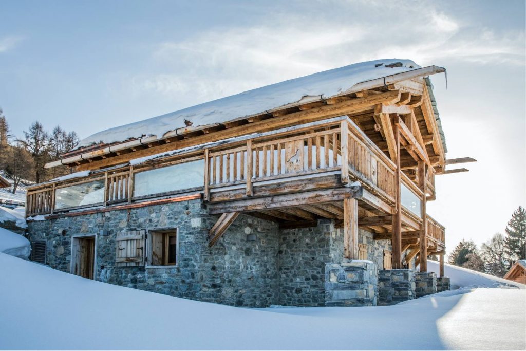 Chalet de montagne traditionnel sous la neige. Charpente bois poteau poutre. Chalet sur mesure