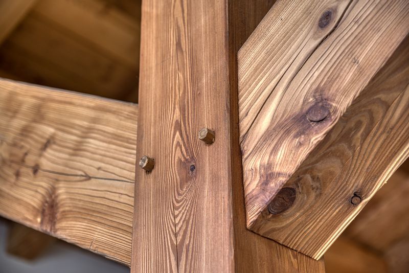 Photo en gros plan d'une pièce d'assemblage de charpente bois pour construction chalet poteau poutre