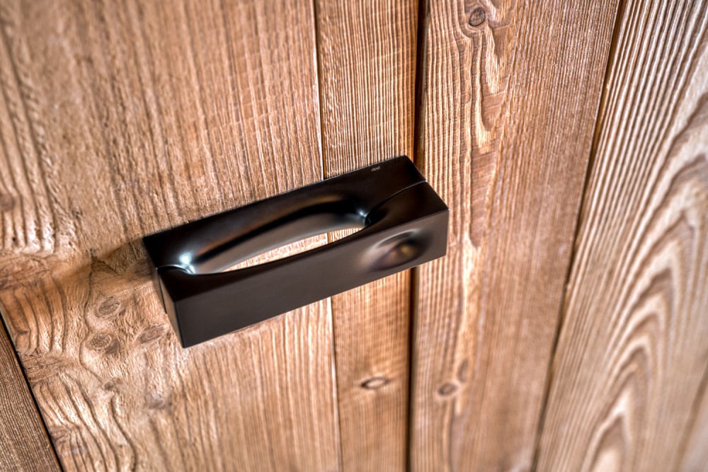 Détail porte sous tenture en mélèze dans chalet bois sur mesure